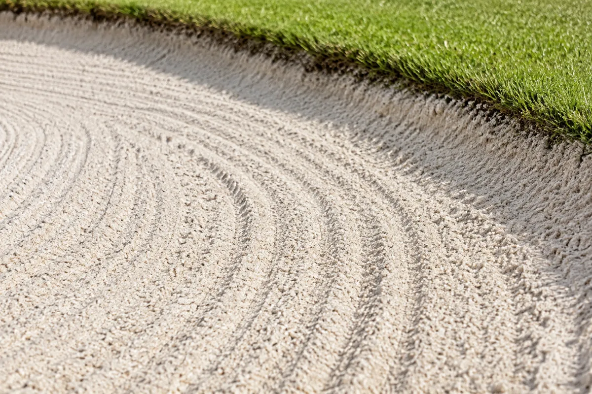 Close-up of pale raked golf bunker sand